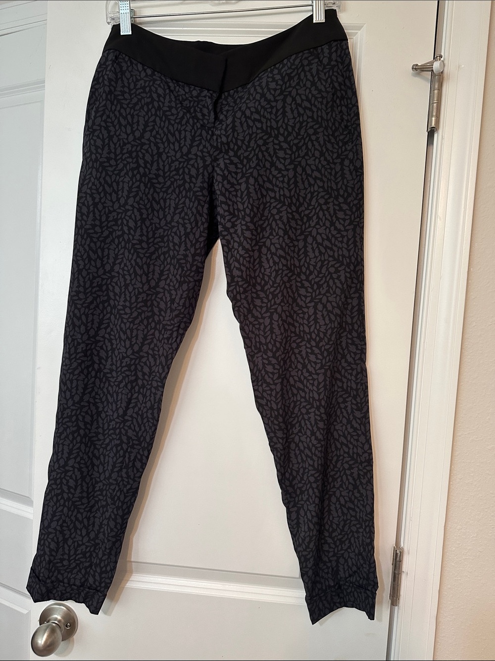 Sz 0 Loft brand pants feature a distinctive black and navy leaf pattern.